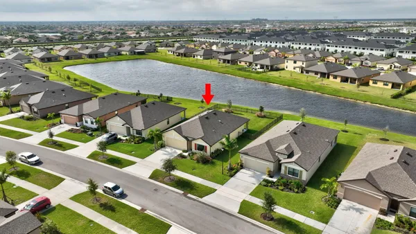 an aerial view of residential houses with outdoor space and parking