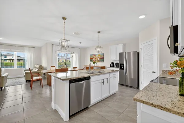 a kitchen with stainless steel appliances granite countertop a sink a stove and a refrigerator