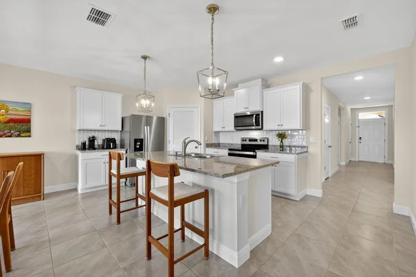 a kitchen with kitchen island granite countertop a sink a center island and cabinets