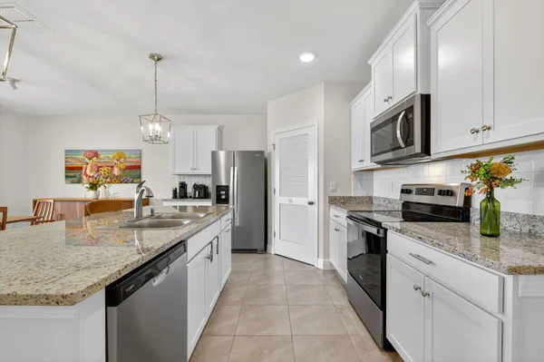 a kitchen with stainless steel appliances granite countertop a sink a stove and a refrigerator