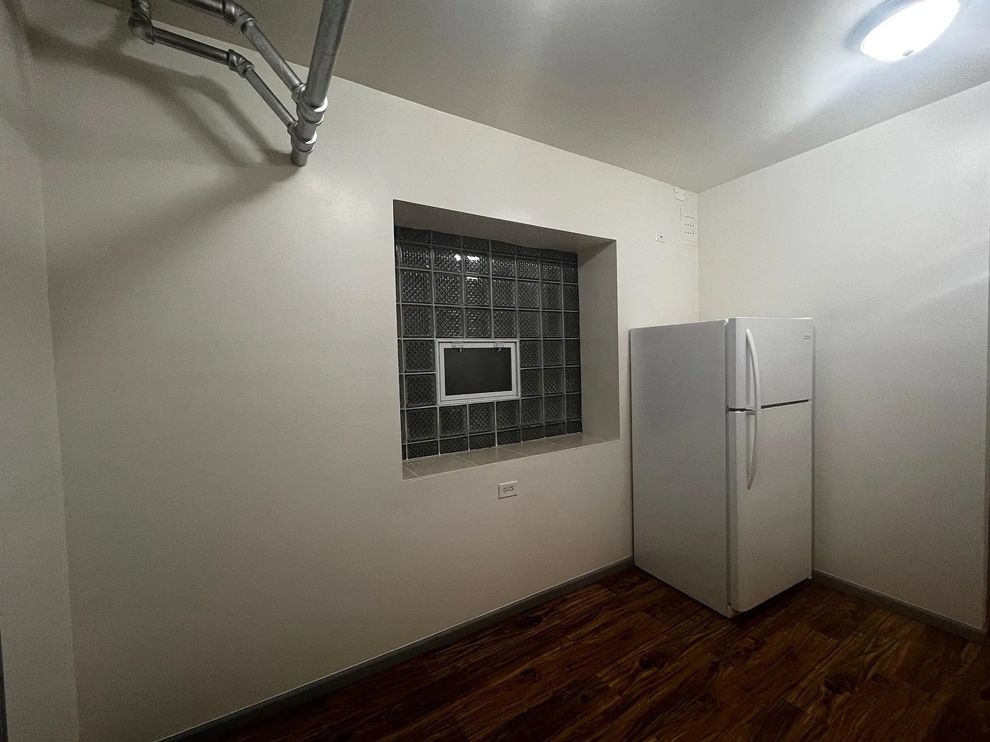 4304 West Shakespeare Avenue Chicago, IL 60639 - Photo 4 of 6 a view of an empty room with wooden floor and a window