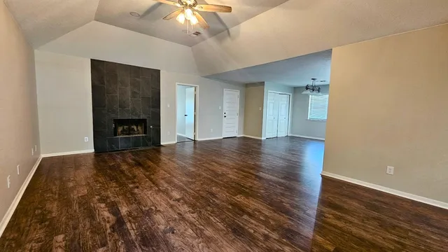 a view of empty room with wooden floor and fireplace