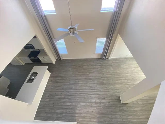 an empty room with a window and a fan