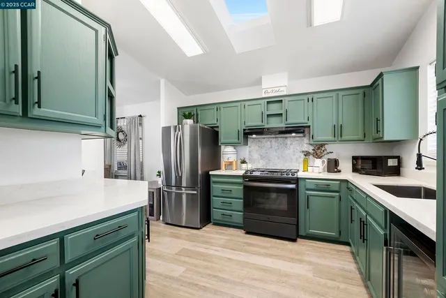 a kitchen with granite countertop a refrigerator and a sink