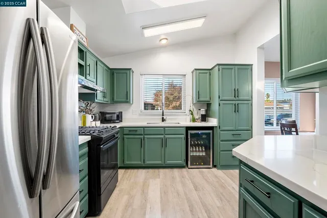 a kitchen with granite countertop a refrigerator stove and sink