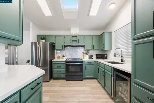 a kitchen with stainless steel appliances granite countertop a sink stove and refrigerator