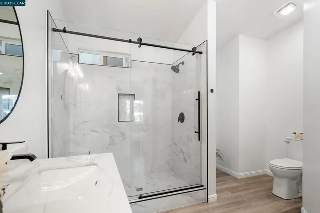 a bathroom with a shower a toilet and a sink