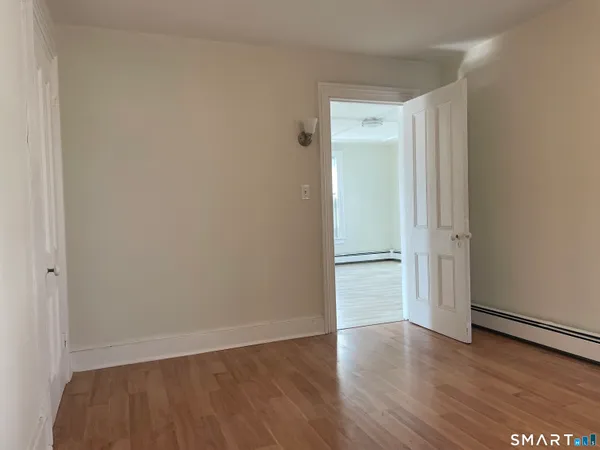 a view of an empty room with wooden floor
