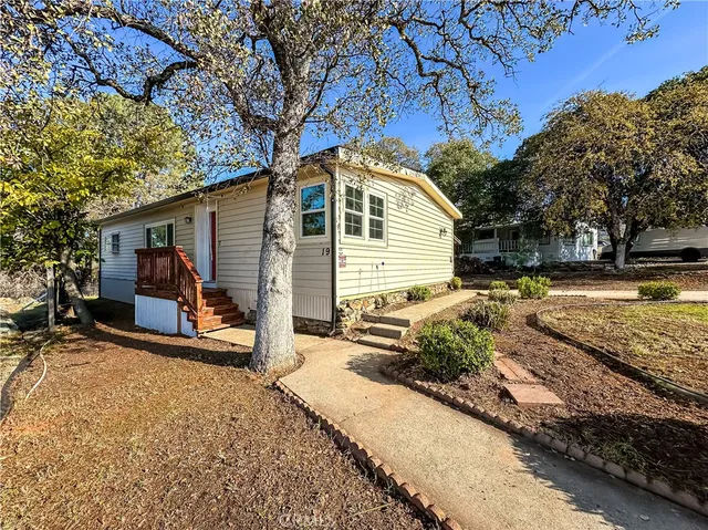 a view of a house with backyard and trees