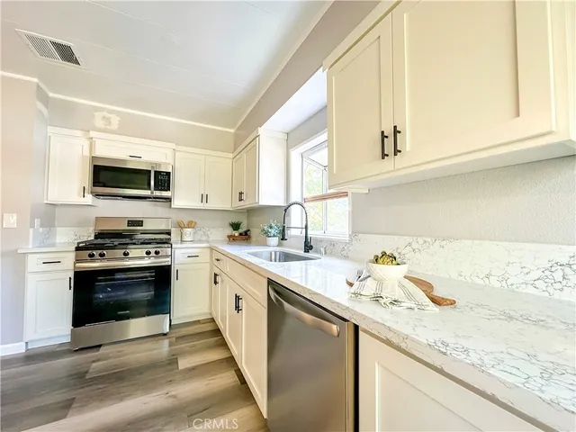a kitchen with stainless steel appliances granite countertop a sink and a stove