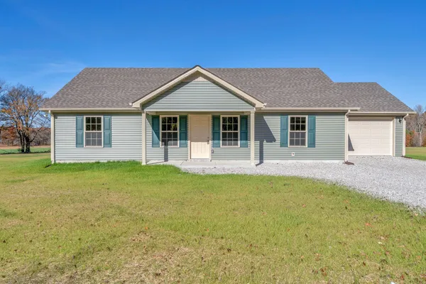 a front view of house with yard and green space