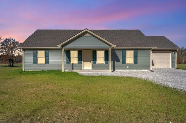 a front view of a house with yard and green space