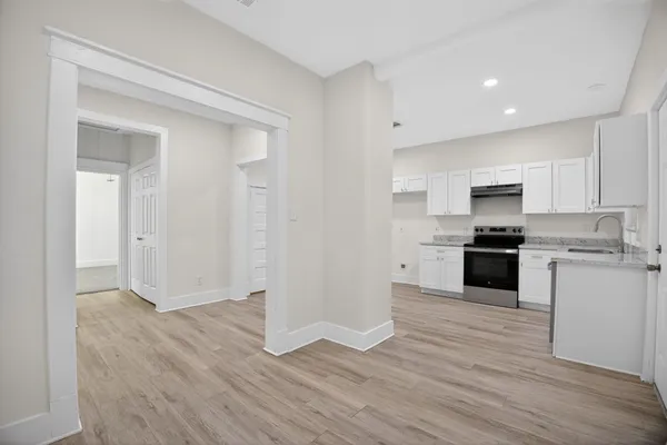 a kitchen with granite countertop white cabinets and stainless steel appliances