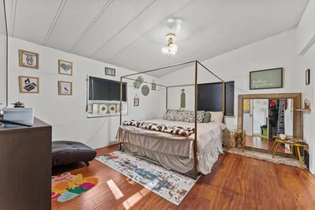 a bedroom with a bed window and a flat screen tv