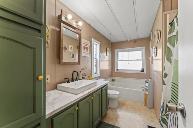 a bathroom with a granite countertop sink a toilet and a mirror