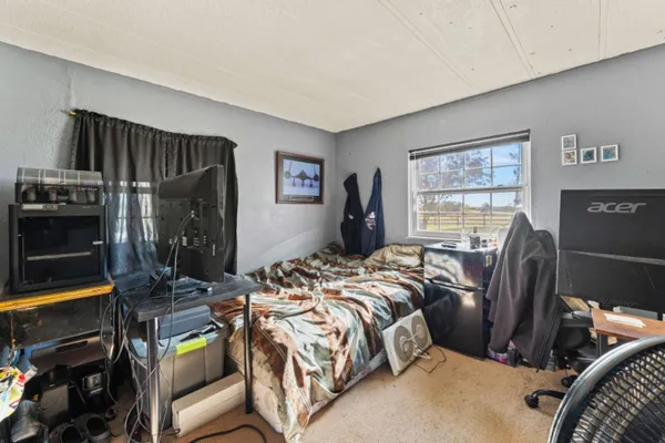 a bed sitting in a bedroom next to a window
