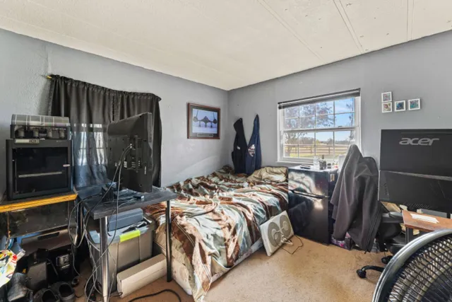 a bed sitting in a bedroom next to a window