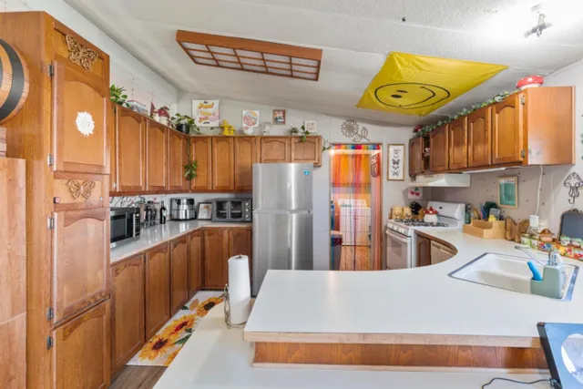 a kitchen with stainless steel appliances granite countertop a refrigerator and a stove top oven