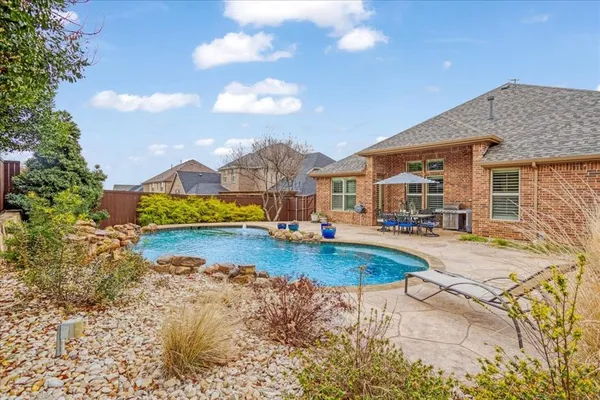 a view of swimming pool of water with lawn chairs and large tree