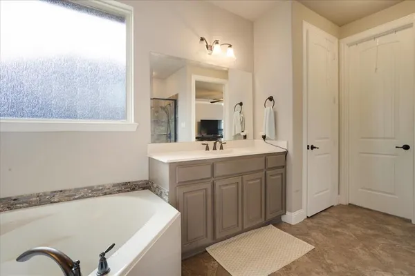a bathroom with a sink a vanity a mirror and a bathtub