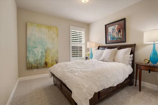 a large bed sitting in a bedroom next to a window