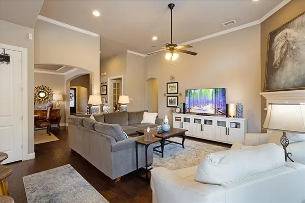 a living room with furniture a flat screen tv and a chandelier