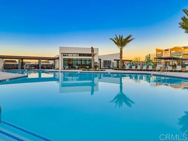 a swimming pool with outdoor seating and lake view