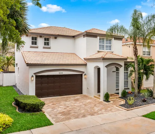 a front view of a house with yard and parking