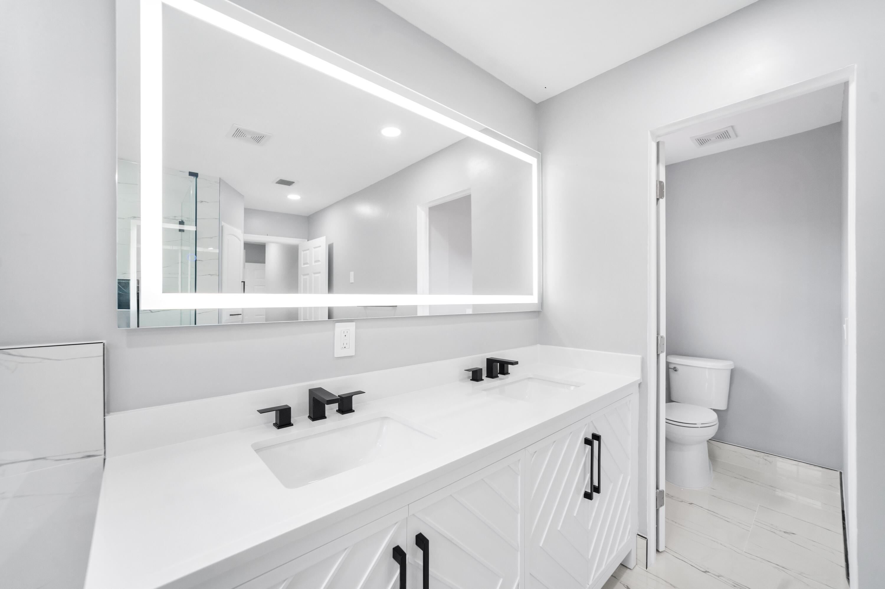 5233 Southwest 155th Way Miramar, FL 33027 - Photo 13 of 63 a bathroom with a sink a toilet and a mirror