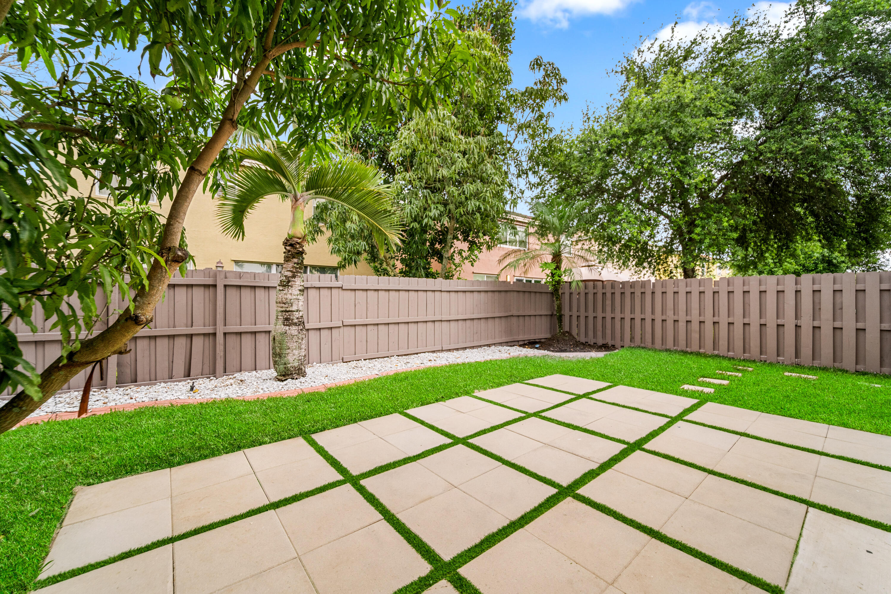 5233 Southwest 155th Way Miramar, FL 33027 - Photo 19 of 63 a view of a backyard with a large tree and wooden fence