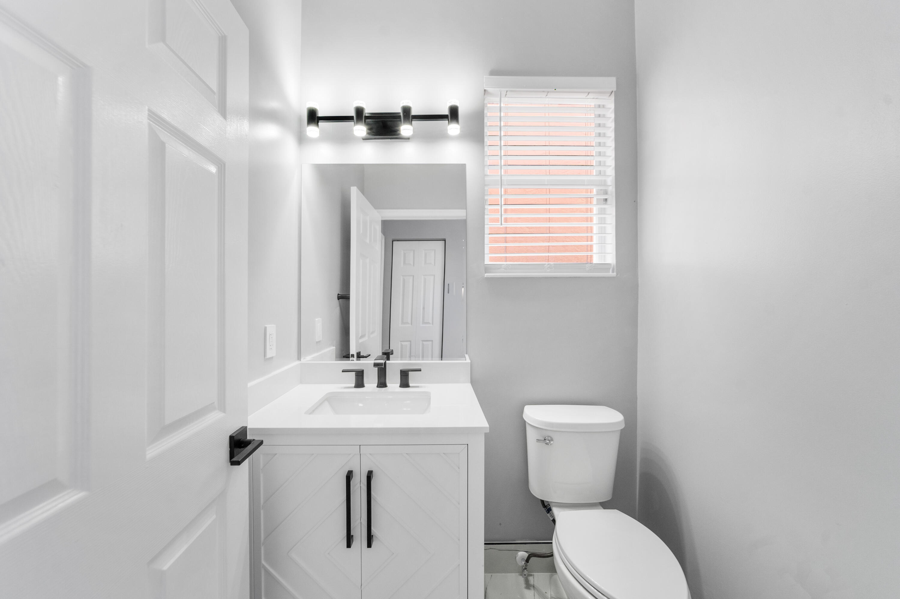 5233 Southwest 155th Way Miramar, FL 33027 - Photo 32 of 63 a bathroom with a toilet a sink and mirror