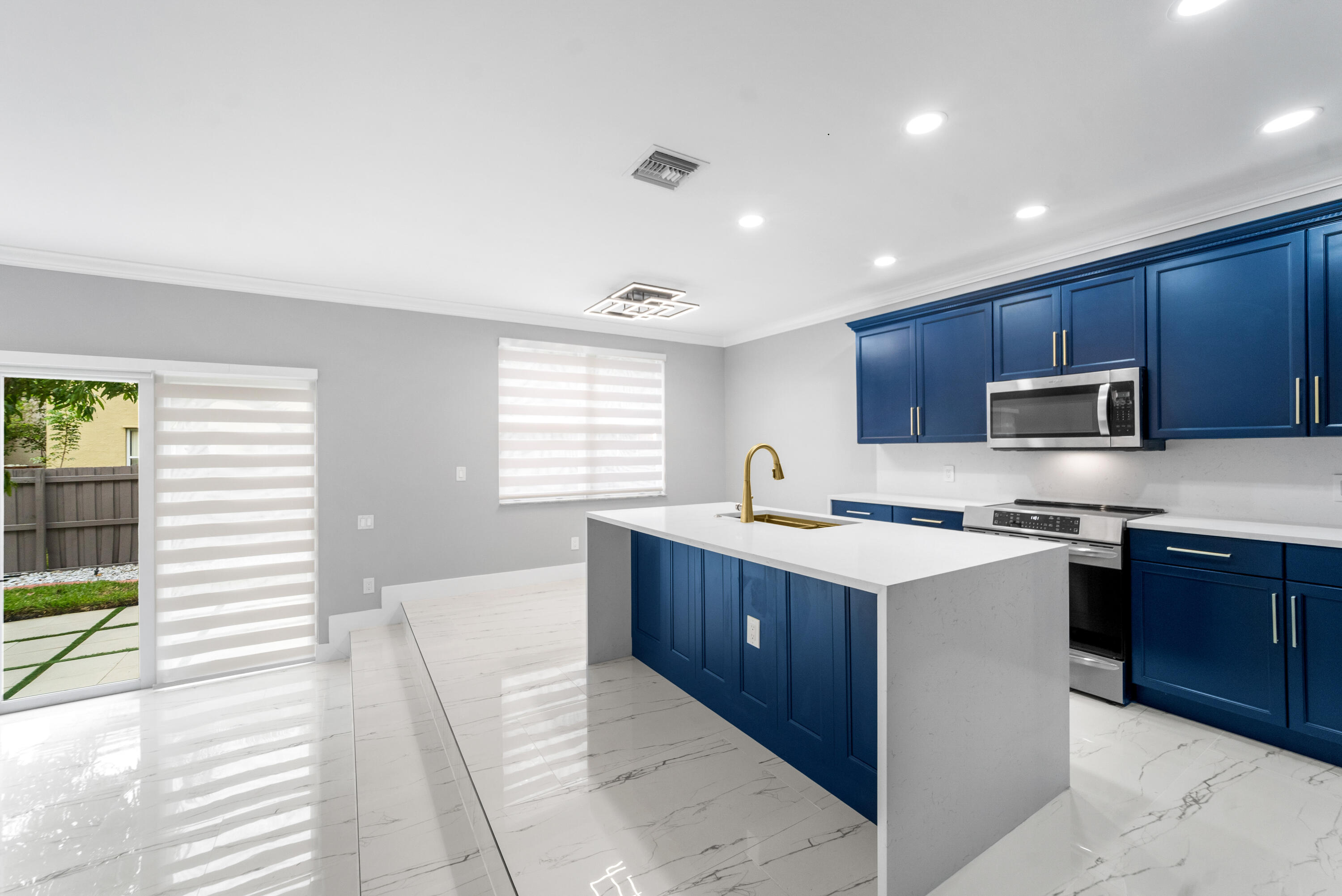 5233 Southwest 155th Way Miramar, FL 33027 - Photo 6 of 63 a kitchen with stainless steel appliances granite countertop a stove top oven a sink dishwasher a refrigerator and white cabinets with wooden floor