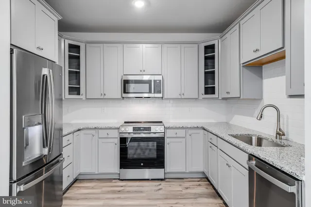a kitchen with stainless steel appliances granite countertop a refrigerator stove and sink
