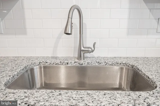 a view of kitchen with sink and stainless steel appliances