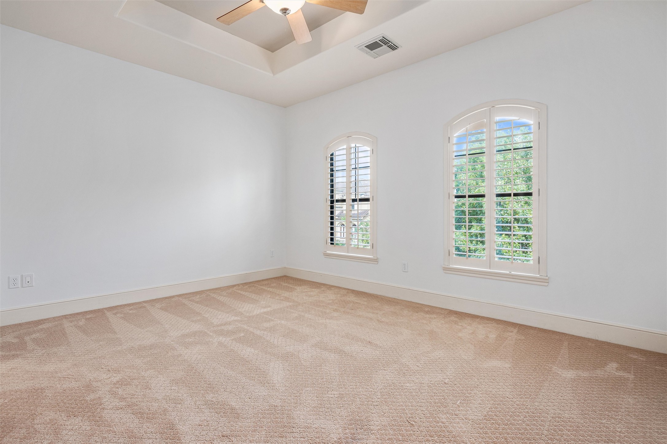 4523 Maple Street Bellaire, TX 77401 - Photo 38 of 50 The home includes three additional guest bedrooms, each featuring plush carpet, decorator paint, a ceiling fan, a closet, and windows that fill the space with natural light. This room also has plantation shutters, a tray ceiling, and shares a hollywood bathroom with room number three.