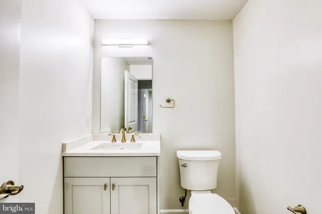 a bathroom with a toilet a sink and mirror