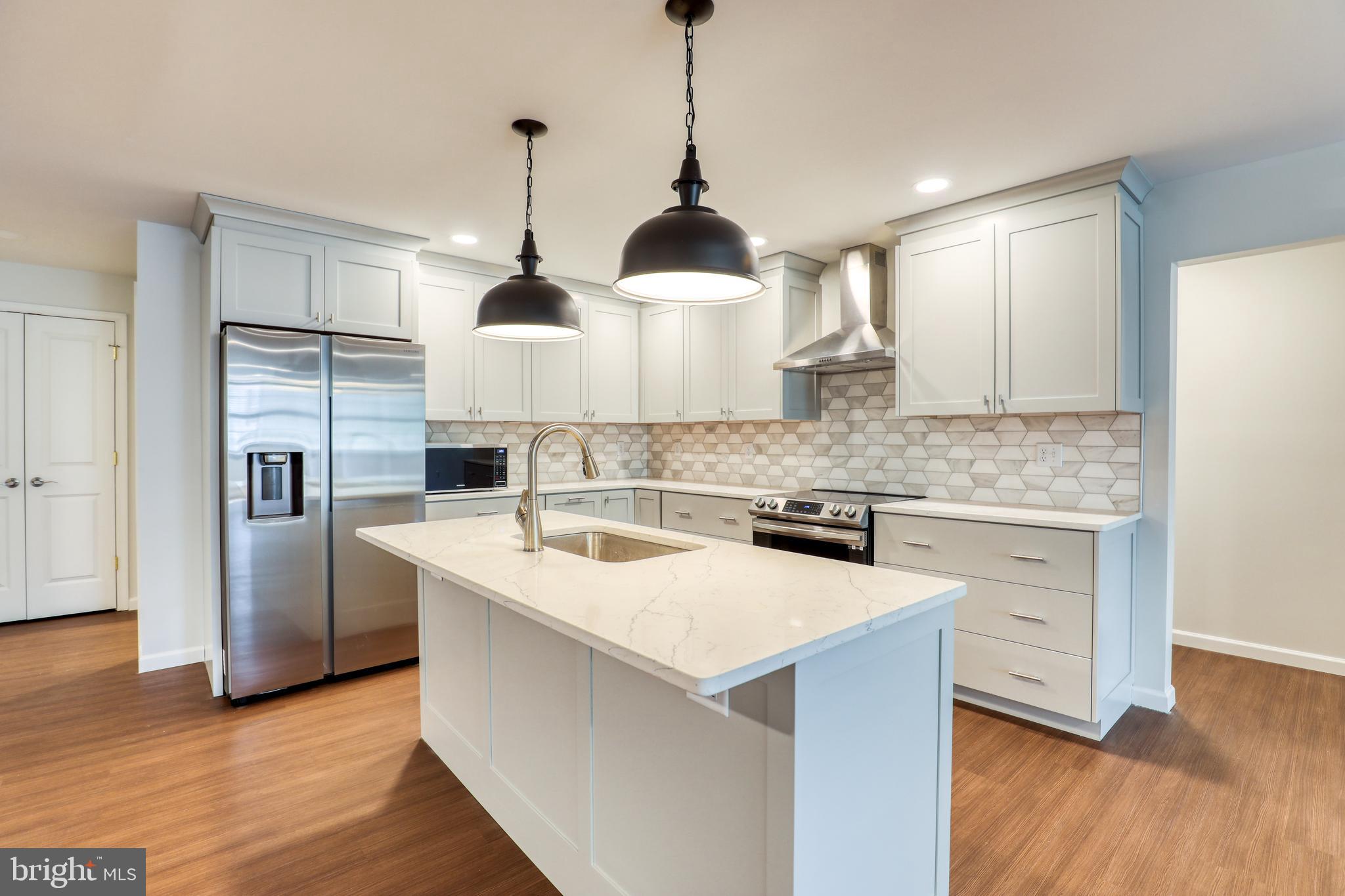 210 East Boscawen Street, Unit 204 Winchester, VA 22601 - Photo 2 of 20 a kitchen with stainless steel appliances granite countertop a sink a stove a refrigerator and island with wooden floor