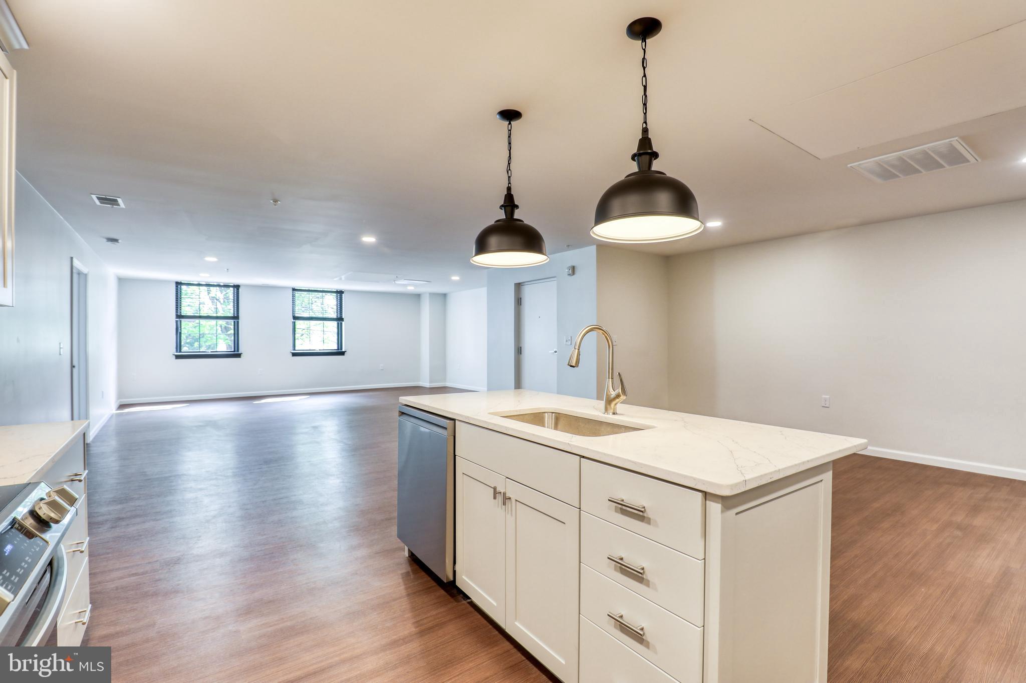 210 East Boscawen Street, Unit 204 Winchester, VA 22601 - Photo 4 of 20 a view of a center island and wooden floor