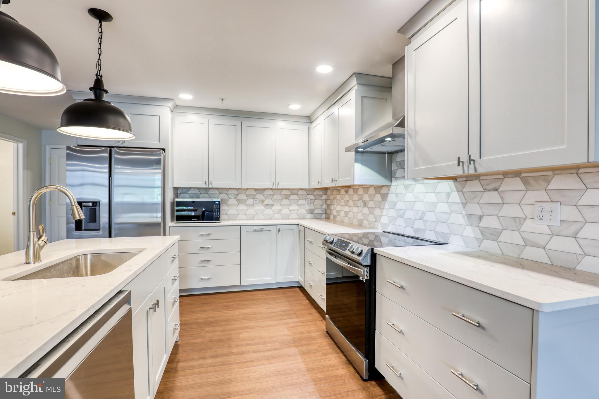 210 East Boscawen Street, Unit 204 Winchester, VA 22601 - Photo 5 of 20 a kitchen with granite countertop a sink stainless steel appliances and cabinets