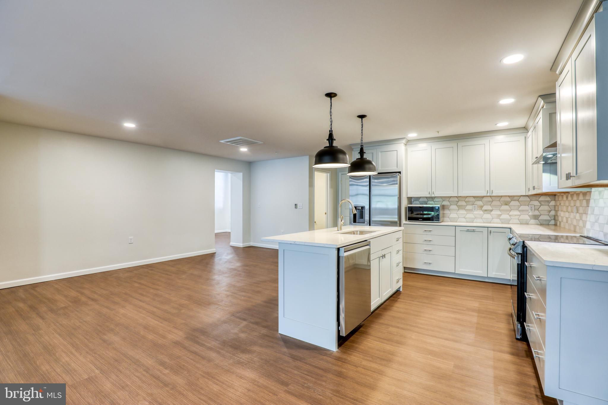 210 East Boscawen Street, Unit 204 Winchester, VA 22601 - Photo 6 of 20 a large kitchen with stainless steel appliances granite countertop a stove and a sink