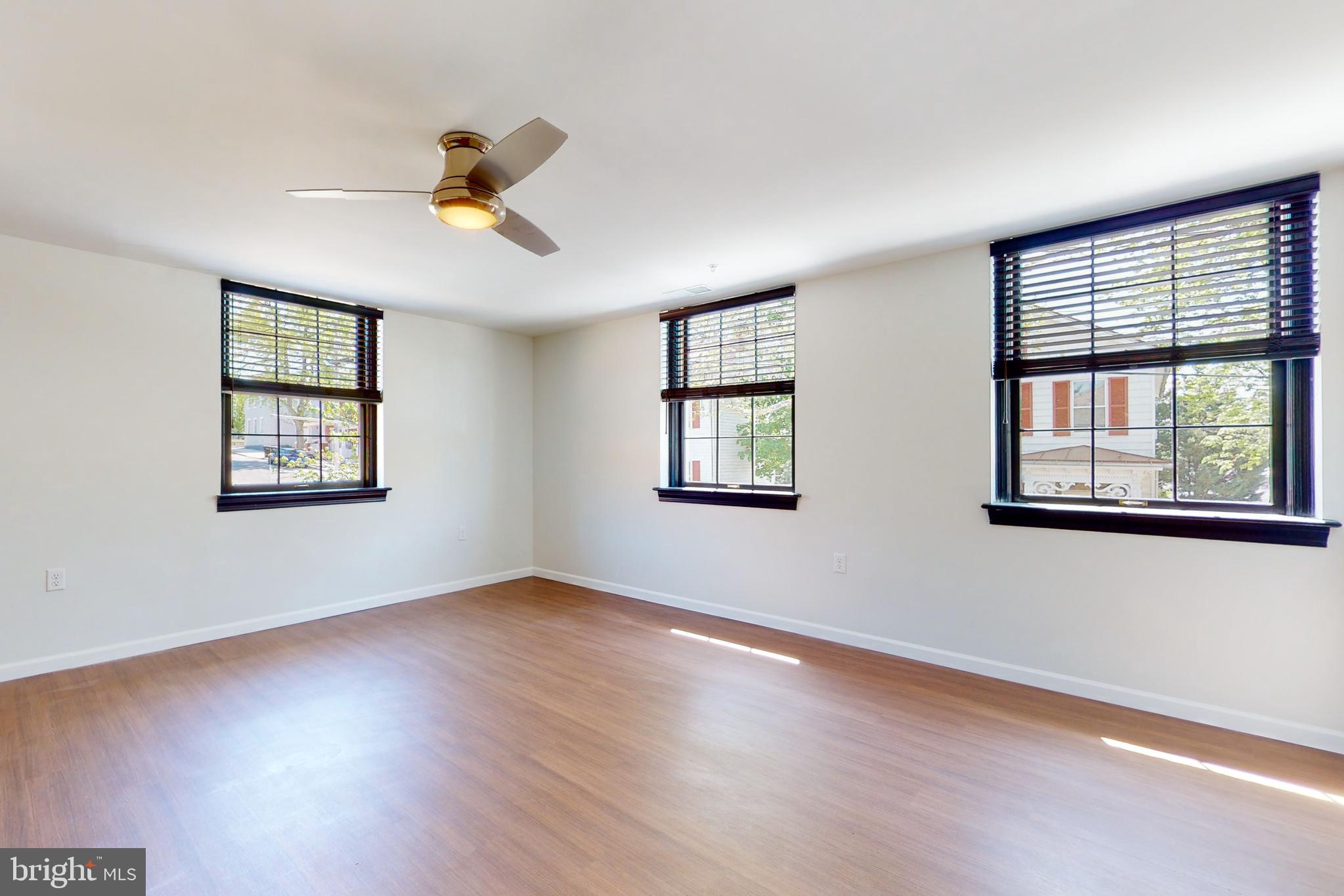 210 East Boscawen Street, Unit 204 Winchester, VA 22601 - Photo 10 of 20 a view of an empty room with a window and wooden floor