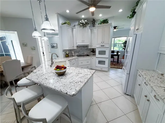 a kitchen with stainless steel appliances granite countertop a sink refrigerator and cabinets