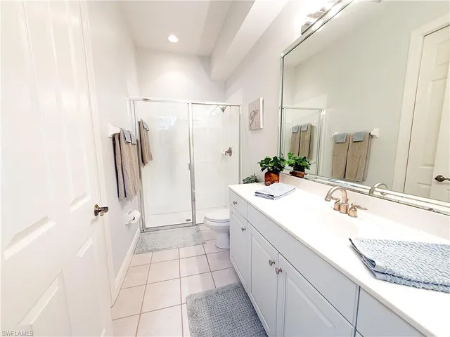 a bathroom with a granite countertop sink a mirror and a shower