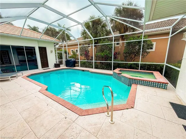 a swimming pool with lawn chairs and a yard