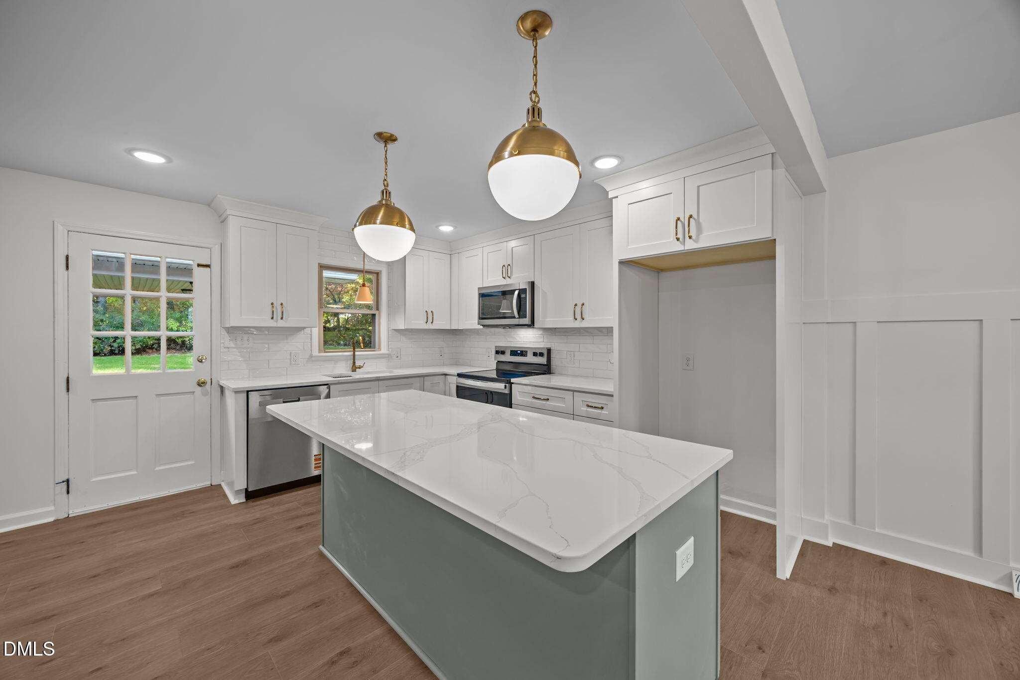 102 Royall Road Oxford, NC 27565 - Photo 9 of 53 a large kitchen with kitchen island a stove a sink a center island and wooden floor
