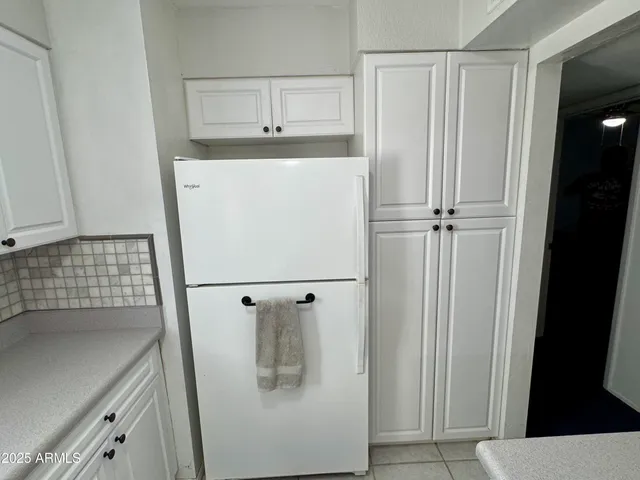 a white refrigerator freezer and a stove sitting inside of a kitchen