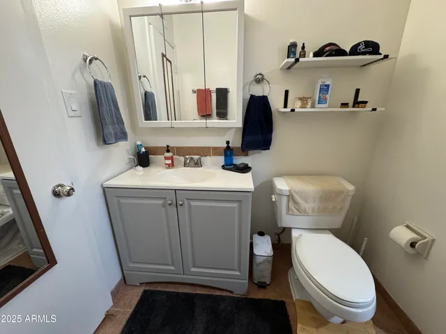 a bathroom with a toilet sink and mirror