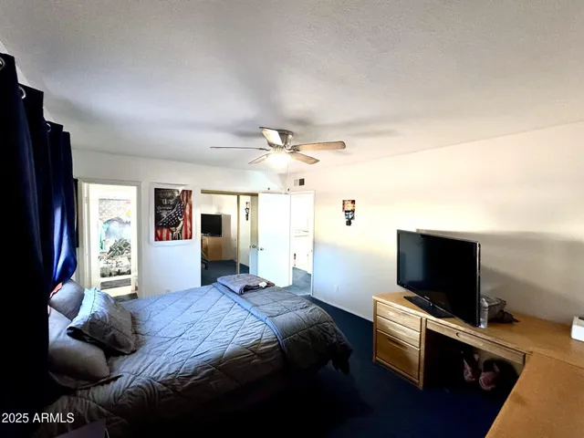 a bedroom with a bed and flat screen tv