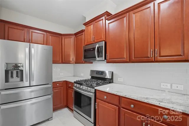 a kitchen with stainless steel appliances granite countertop a sink stove and microwave