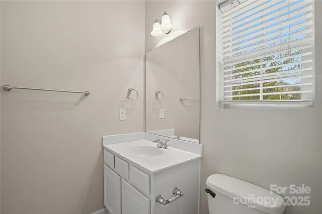 an empty room with chandelier fan and closet area